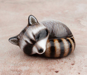 sleeping raccoon figurine